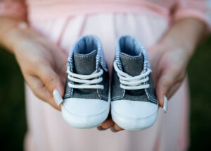 a person holding a pair of baby shoes